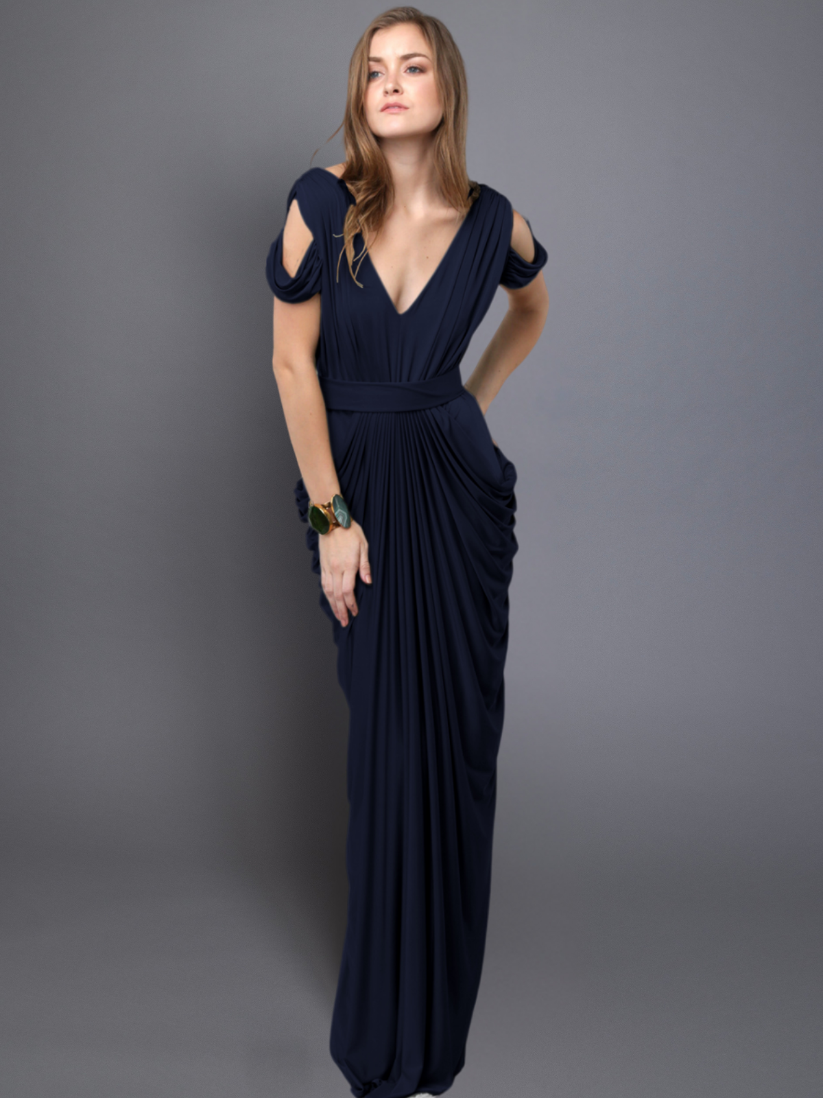 Woman wearing a navy blue evening gown against a gray background