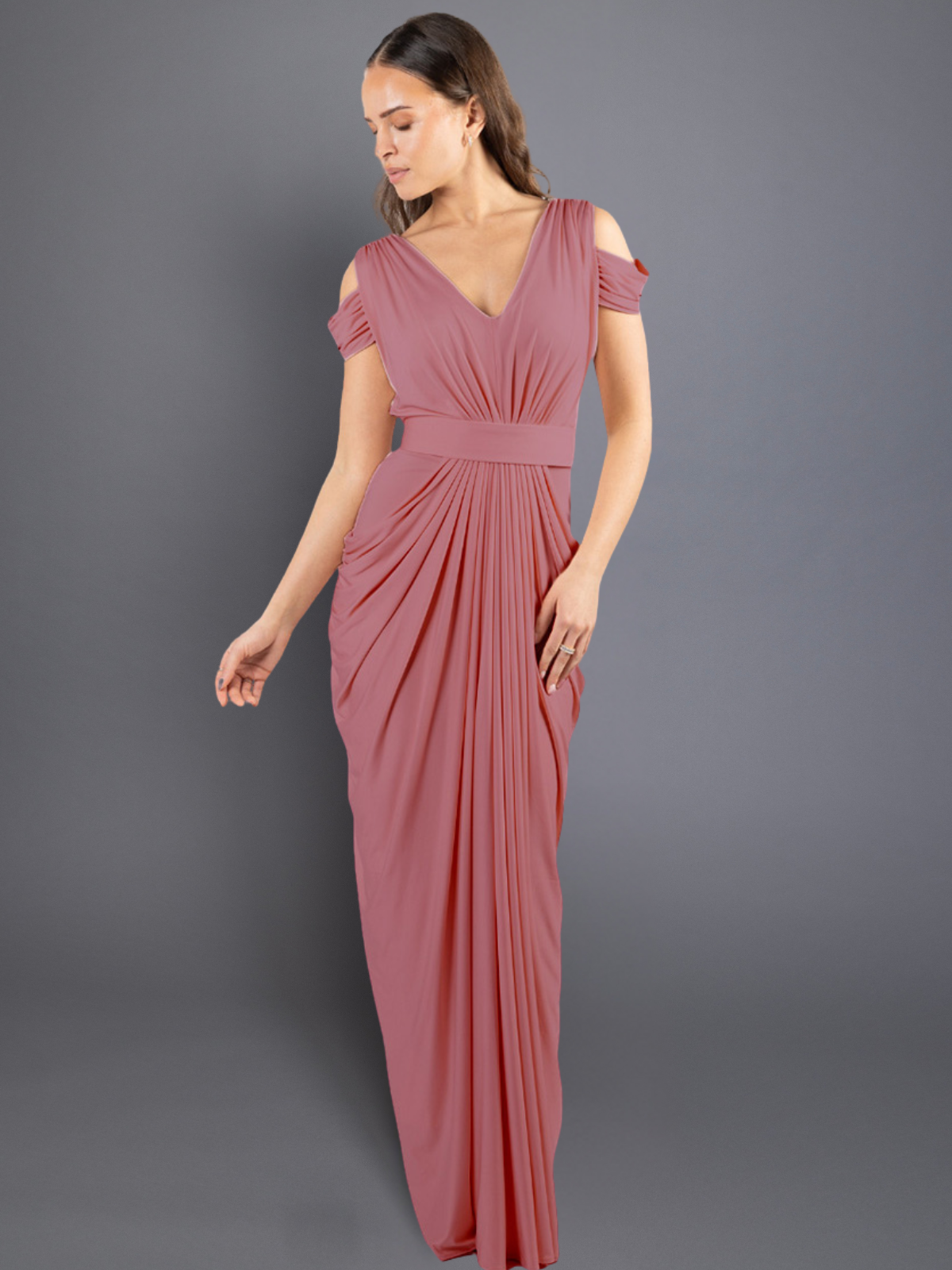 Woman wearing a pink evening gown against a gray background
