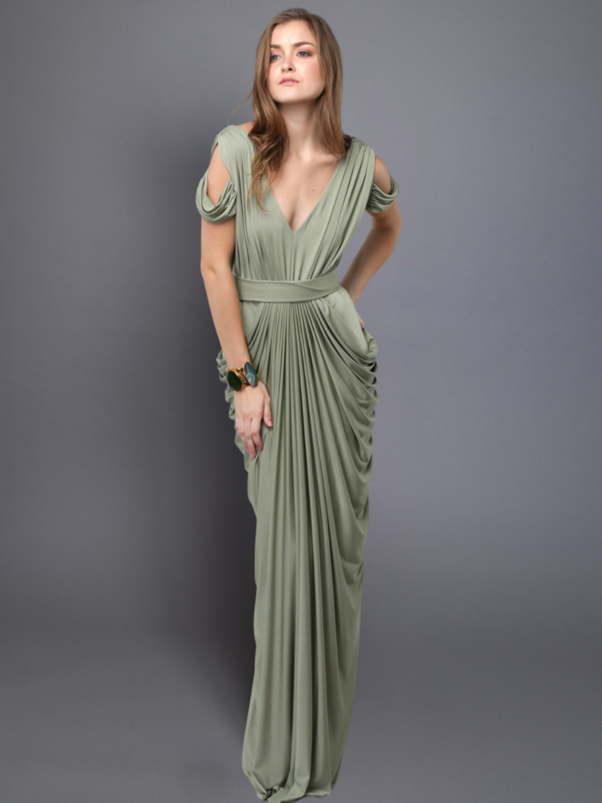 Woman wearing a green evening gown against a gray background
