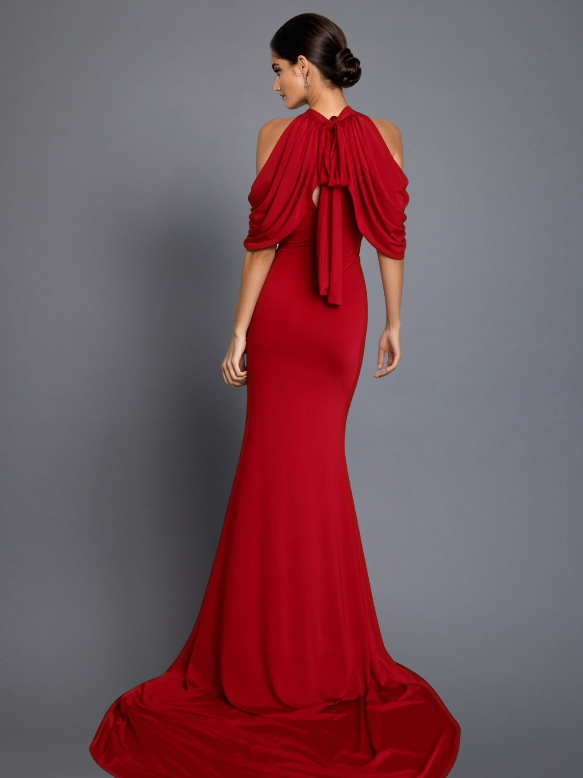 Red evening gown with a draped design on a gray background